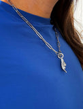 Person wearing a silver stainless steel Italian Hand pendant—also known as Mano Cornuta or the “Horned Hand” amulet.  Designed for everyone who values inclusivity, diversity, and meaning, it’s a timeless statement of strength and modern style. It's perfect for everyday wear. Designed by AAPI celebrity jewelry designer SONIA HOU.