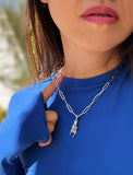 Person wearing a silver stainless steel Italian Hand pendant—also known as Mano Cornuta or the “Horned Hand” amulet.  Designed for everyone who values inclusivity, diversity, and meaning, it’s a timeless statement of strength and modern style. It's perfect for everyday wear. Designed by AAPI celebrity jewelry designer SONIA HOU.