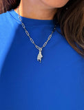 Person wearing a silver stainless steel Italian Hand pendant—also known as Mano Cornuta or the “Horned Hand” amulet.  Designed for everyone who values inclusivity, diversity, and meaning, it’s a timeless statement of strength and modern style. It's perfect for everyday wear. Designed by AAPI celebrity jewelry designer SONIA HOU.