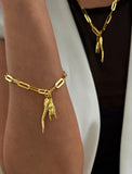 18K Gold vermeil (sterling silver) chain bracelet with a unique pendant on a wrist against a neutral background. Inspired by centuries-old Italian tradition, this modern chain bracelet features the Italian horn and hand charm, also known as the cornicello and Mano Cornuta — a powerful symbol of protection, good fortune, and strength. Designed by AAPI celebrity jewelry designer SONIA HOU.
