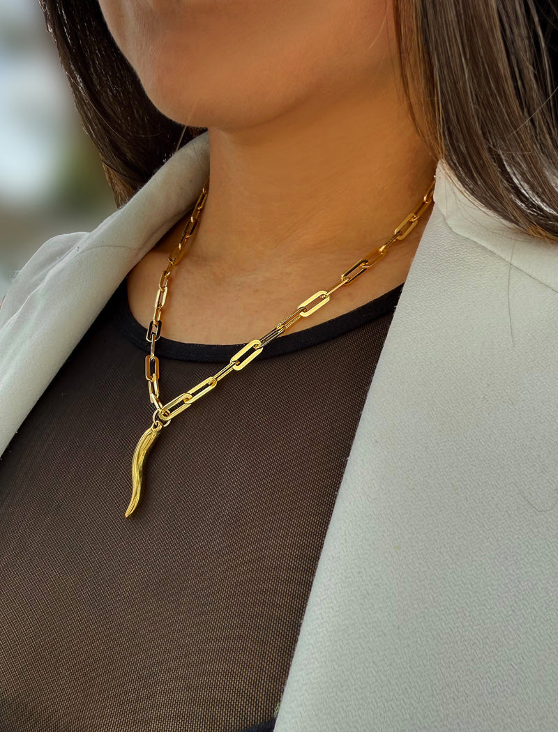 Inspired by centuries-old Italian tradition, this photo showcases a person wearing a modern chain pendant necklace with the Italian Horn —also known as the cornicello—a powerful emblem of protection, strength, and good fortune. Made of 18K Gold Vermeil (sterling Silver base).  Designed for everyone who values inclusivity, diversity, and meaning, it’s a timeless statement of strength and modern style. It's perfect for everyday wear. Designed by AAPI celebrity jewelry designer SONIA HOU.