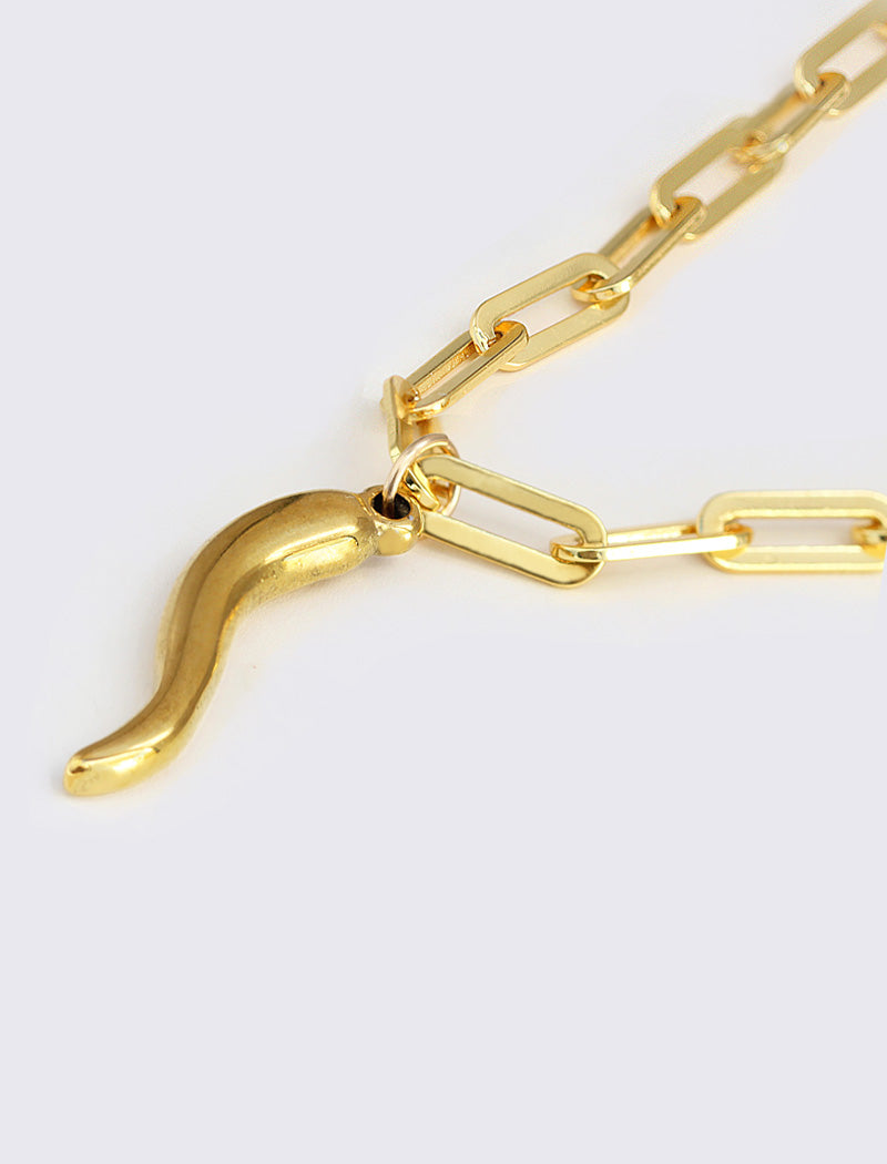 Inspired by centuries-old Italian tradition, this photo showcases a person wearing a modern chain pendant necklace with the Italian Horn —also known as the cornicello—a powerful emblem of protection, strength, and good fortune. Made of 18K Gold PVD Stainless Steel (waterproof)..  Designed for everyone who values inclusivity, diversity, and meaning, it’s a timeless statement of strength and modern style. It's perfect for everyday wear. Designed by AAPI celebrity jewelry designer SONIA HOU.
