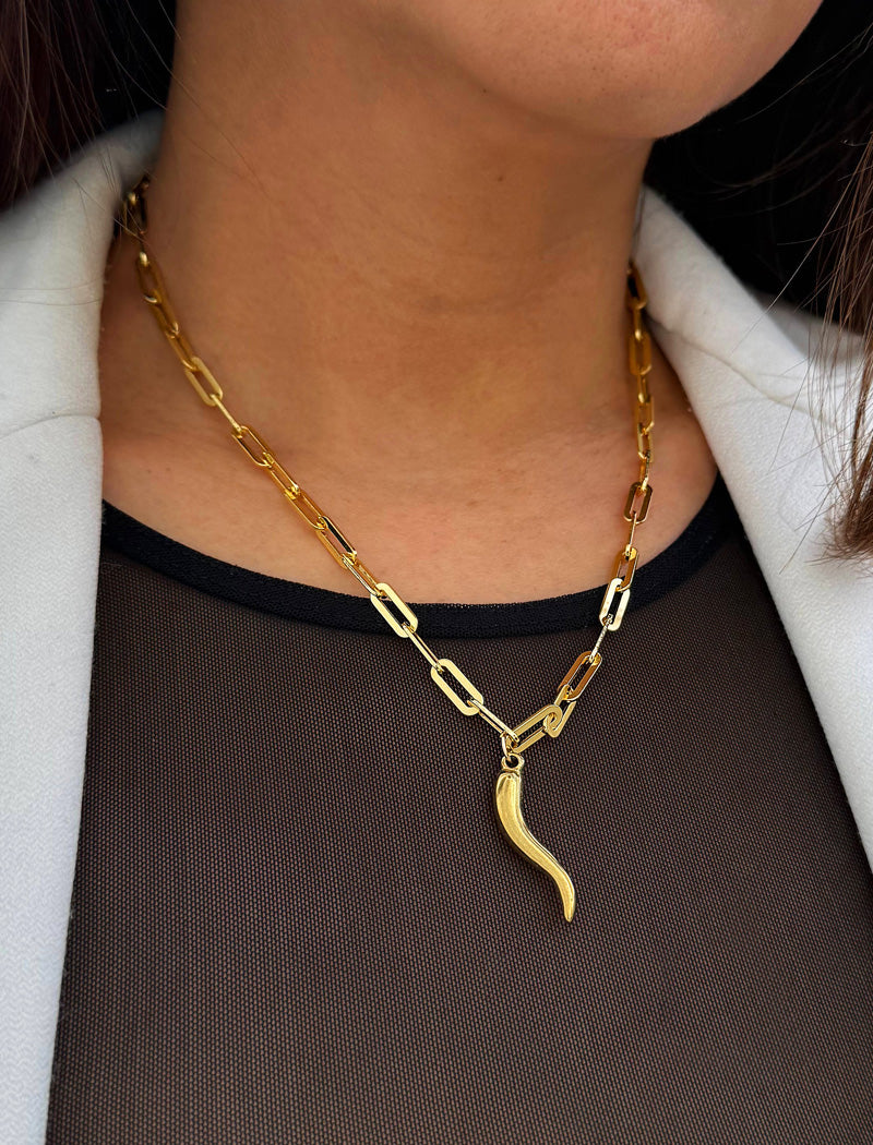 Inspired by centuries-old Italian tradition, this photo showcases a person wearing a modern chain pendant necklace with the Italian Horn —also known as the cornicello—a powerful emblem of protection, strength, and good fortune. Made of 18K Gold PVD Stainless Steel (waterproof)..  Designed for everyone who values inclusivity, diversity, and meaning, it’s a timeless statement of strength and modern style. It's perfect for everyday wear. Designed by AAPI celebrity jewelry designer SONIA HOU.