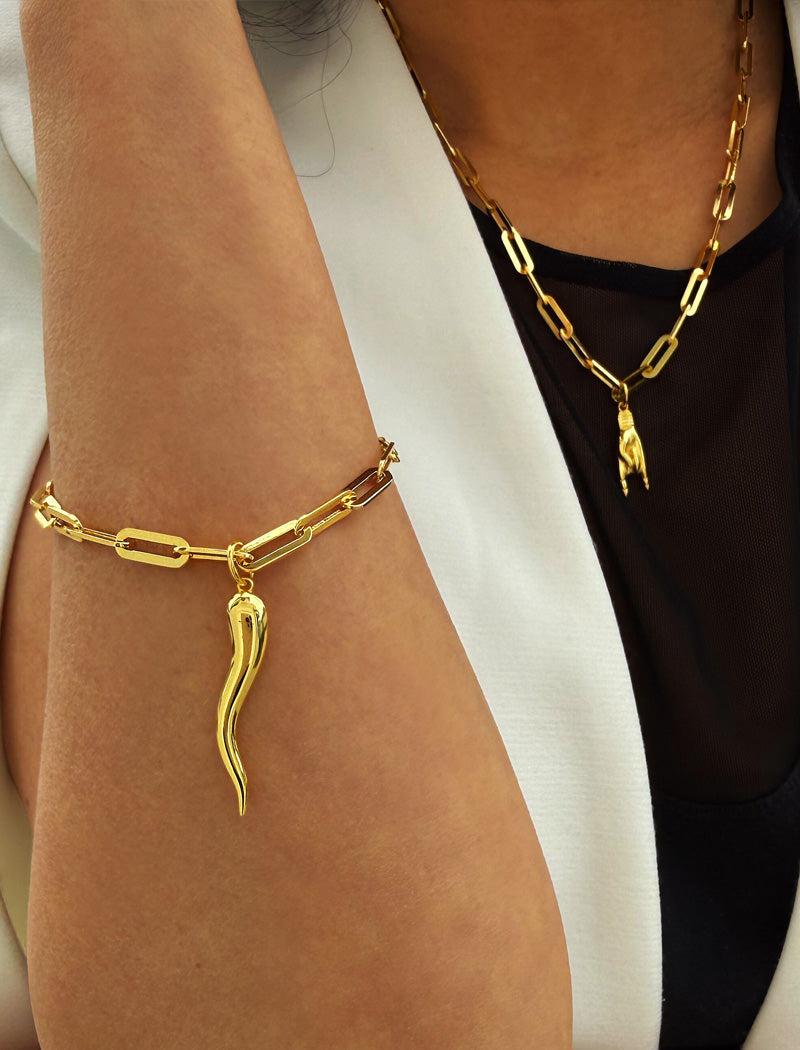 18K Gold vermeil (sterling silver) chain bracelet with a unique pendant on a wrist against a neutral background. Inspired by centuries-old Italian tradition, this modern chain bracelet features the Italian horn charm, also known as the cornicello — a powerful symbol of protection, good fortune, and strength. Designed by AAPI celebrity jewelry designer SONIA HOU.

