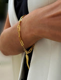 18K Gold vermeil (sterling silver) chain bracelet with a unique pendant on a wrist against a neutral background. Inspired by centuries-old Italian tradition, this modern chain bracelet features the Italian horn charm, also known as the cornicello — a powerful symbol of protection, good fortune, and strength. Designed by AAPI celebrity jewelry designer SONIA HOU.

