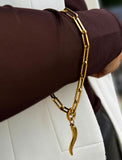 18K Gold stainless steel (waterproof) chain bracelet with a unique clasp worn by a person in a brown long-sleeve shirt. Inspired by centuries-old Italian tradition, this modern chain bracelet features the Italian horn charm, also known as the cornicello — a powerful symbol of protection, good fortune, and strength. Designed by AAPI celebrity jewelry designer SONIA HOU.
