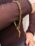 18K Gold stainless steel (waterproof) chain bracelet with a unique clasp worn by a person in a brown long-sleeve shirt. Inspired by centuries-old Italian tradition, this modern chain bracelet features the Italian horn charm, also known as the cornicello — a powerful symbol of protection, good fortune, and strength. Designed by AAPI celebrity jewelry designer SONIA HOU.
