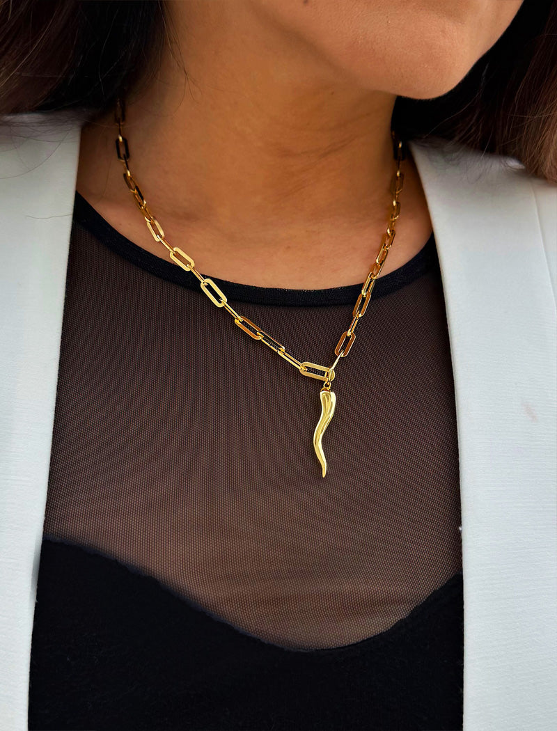 Inspired by centuries-old Italian tradition, this photo showcases a person wearing a modern chain pendant necklace with the Italian Horn —also known as the cornicello—a powerful emblem of protection, strength, and good fortune. Made of 18K Gold Vermeil (sterling Silver base).  Designed for everyone who values inclusivity, diversity, and meaning, it’s a timeless statement of strength and modern style. It's perfect for everyday wear. Designed by AAPI celebrity jewelry designer SONIA HOU.