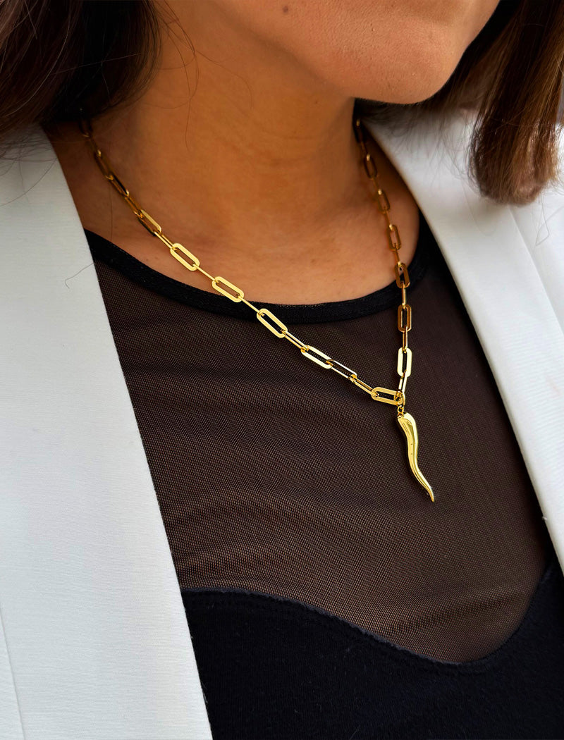 Inspired by centuries-old Italian tradition, this photo showcases a person wearing a modern chain pendant necklace with the Italian Horn —also known as the cornicello—a powerful emblem of protection, strength, and good fortune. Made of 18K Gold Vermeil (sterling Silver base).  Designed for everyone who values inclusivity, diversity, and meaning, it’s a timeless statement of strength and modern style. It's perfect for everyday wear. Designed by AAPI celebrity jewelry designer SONIA HOU.