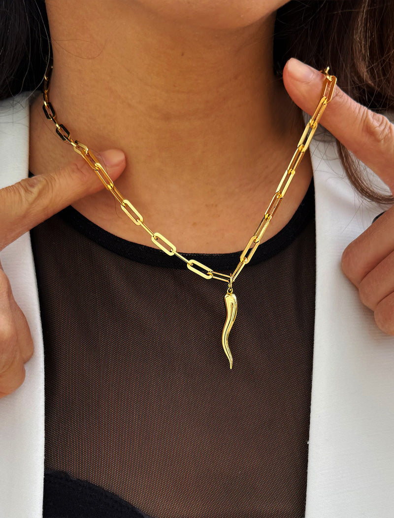 Inspired by centuries-old Italian tradition, this photo showcases a person wearing a modern chain pendant necklace with the Italian Horn —also known as the cornicello—a powerful emblem of protection, strength, and good fortune. Made of 18K Gold Vermeil (sterling Silver base).  Designed for everyone who values inclusivity, diversity, and meaning, it’s a timeless statement of strength and modern style. It's perfect for everyday wear. Designed by AAPI celebrity jewelry designer SONIA HOU.