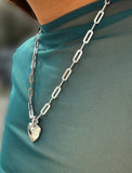 Sterling Silver chain necklace with a heart pendant on a teal shirt. A modern expression of love and strength, this Puffy Heart Necklace reimagines the classic heart symbol with a fresh, contemporary twist. Designed by AAPI celebrity jewelry designer SONIA HOU.
