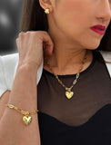 18K Gold vermeil chain necklace with a heart pendant worn by a person. Featuring a bold yet feminine Puffy Heart charm suspended from a sleek link chain, this bracelet radiates effortless confidence and charm. Designed to symbolize love, self-expression, and empowerment, the puffy heart serves as a daily reminder to lead with compassion and strength — Designed by AAPI celebrity jewelry designer SONIA HOU.
