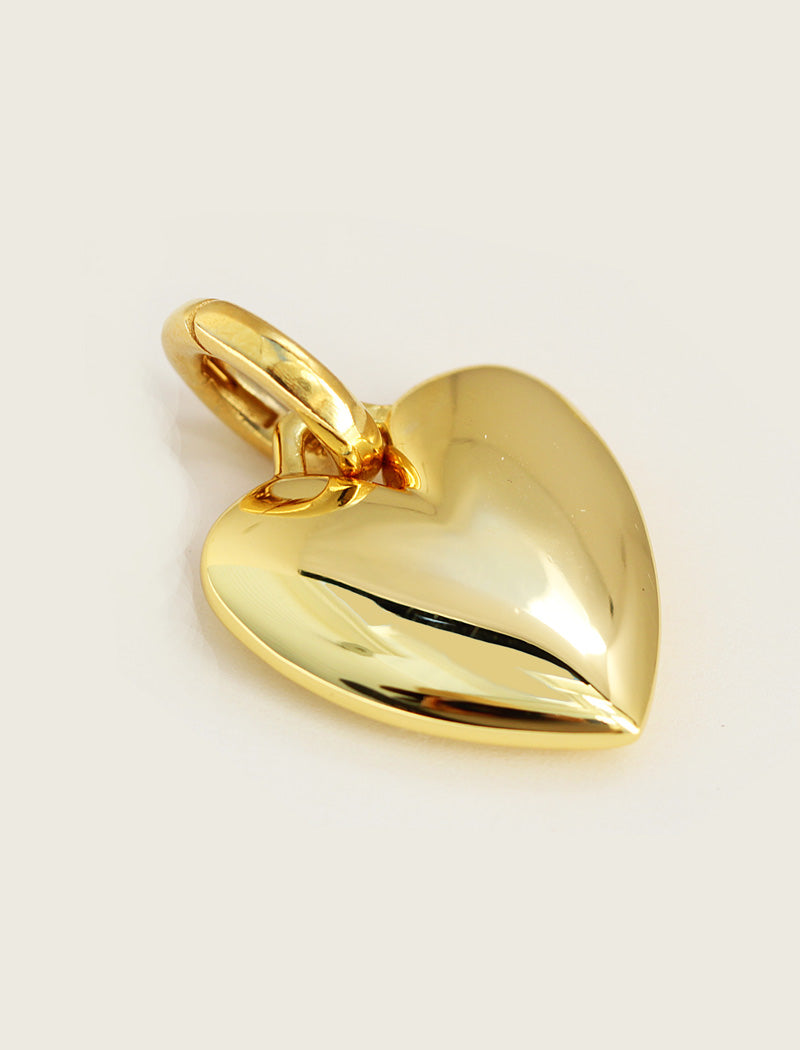 Gold heart-shaped pendant on a light beige background