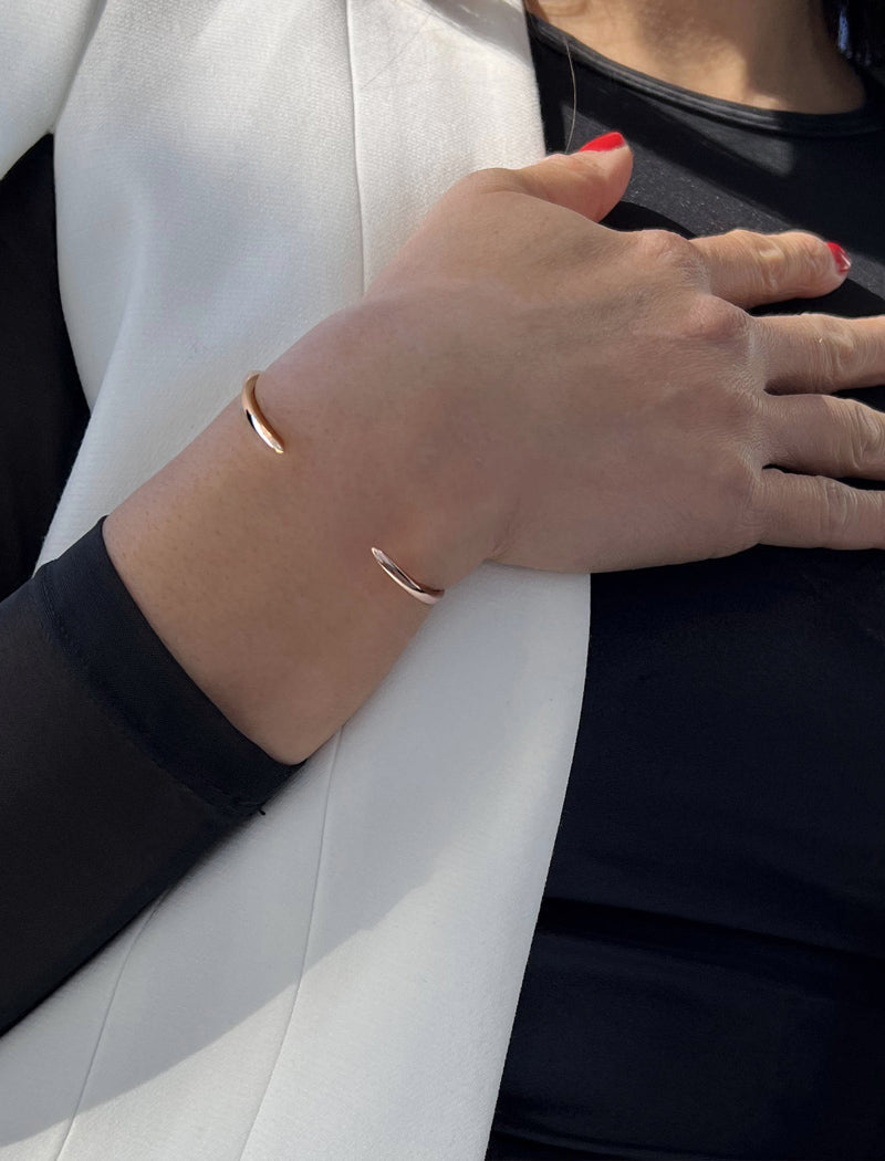 Female model wearing adjustable minimalist simple Success Thin Cuff Chunky Bold Layering Stacking Statement 2 Way convertible Bangle Cuff Open Bracelet in 18K rose gold vermeil with 925 sterling silver base by Sonia Hou, a celebrity AAPI Chinese demi-fine fashion costume jewelry designer