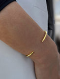 Female model wearing adjustable minimalist simple Success Thin Cuff Chunky Bold Layering Stacking Statement 2 Way convertible Bangle Cuff Open Bracelet in 18K Gold Vermeil with 925 sterling silver base by Sonia Hou, a celebrity AAPI Chinese demi-fine fashion costume jewelry designer