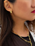 Close-up of a person wearing a gold earring and necklace. Delicately crafted from 18K gold and sterling silver, these modern Teardrop Earrings are more than a timeless accessory — they’re a symbol of strength, resilience, and beauty. The elegant teardrop shape captures life’s emotions with grace, turning a simple gesture into a statement of empowerment. Designed by AAPI celebrity jewelry designer SONIA HOU.
