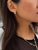 Close-up of a person wearing silver earrings and a necklace. Delicately crafted from sterling silver, these modern Teardrop Earrings are more than a timeless accessory — they’re a symbol of strength, resilience, and beauty. The elegant teardrop shape captures life’s emotions with grace, turning a simple gesture into a statement of empowerment. Designed by AAPI celebrity jewelry designer SONIA HOU.