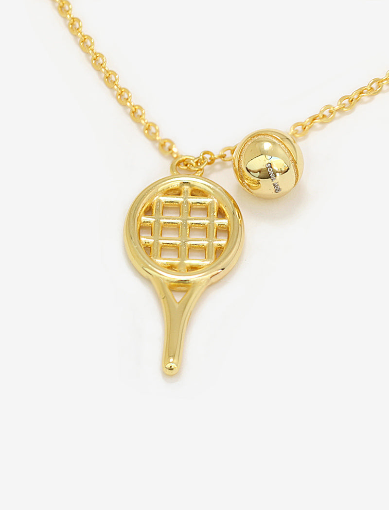 A gold tennis-themed necklace featuring a tennis racket pendant and a small tennis ball charm on a delicate chain, set against a plain white background by Sonia Hou, a celebrity AAPI inclusive demi-fine jewelry designer. Available in 18K Gold Over Sterling Silver, Sterling Silver and 18K Gold PVD Stainless Steel (Waterproof).