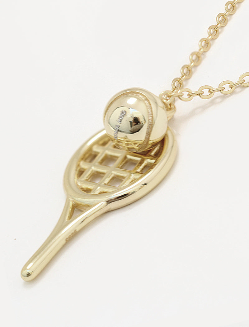 A silver tennis racket pendant necklace with a small silver tennis ball resting on the racket head, shown on a clean white background by Sonia Hou, a celebrity AAPI inclusive demi-fine jewelry designer. Available in 18K Gold Over Sterling Silver, Sterling Silver and 18K Gold PVD Stainless Steel (Waterproof).