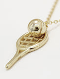 A silver tennis racket pendant necklace with a small silver tennis ball resting on the racket head, shown on a clean white background by Sonia Hou, a celebrity AAPI inclusive demi-fine jewelry designer. Available in 18K Gold Over Sterling Silver, Sterling Silver and 18K Gold PVD Stainless Steel (Waterproof).