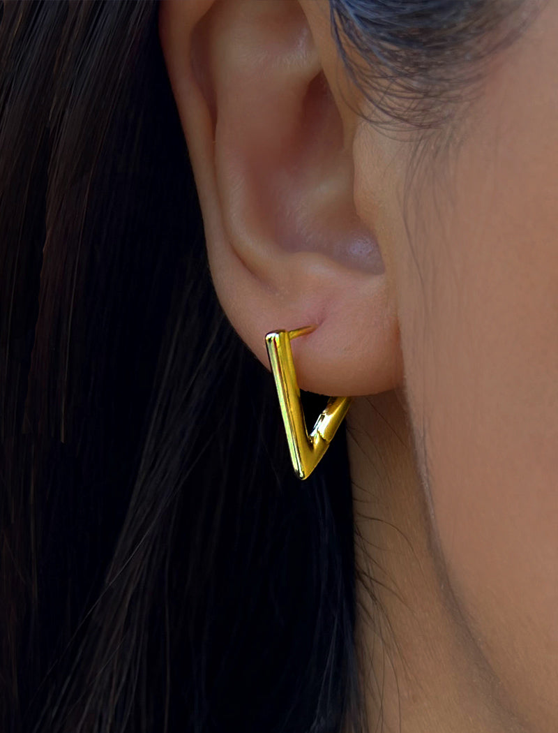 Female model wearing ACHIEVE TRIANGLE GEOMETRIC HUGGIE EARRINGS IN 18K GOLD VERMEIL With Sterling Silver base by Sonia Hou Jewelry