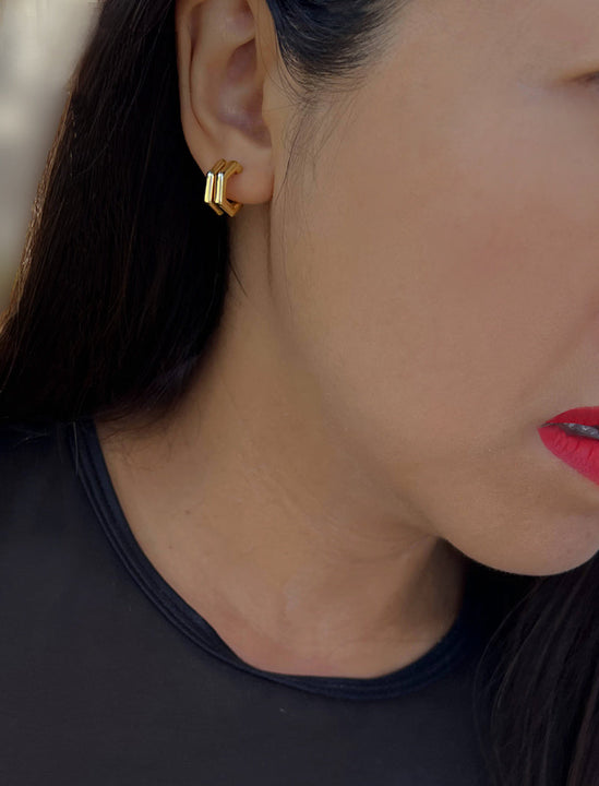 Female model wearing FUTURISTIC DOUBLE HEXAGON HUGGIE EARRINGS IN 18K GOLD VERMEIL by Sonia Hou Jewelry