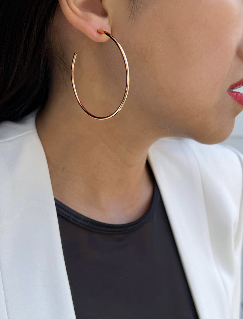 Female model wearing big medium large thin round circle PERFECT 50mm 2 inch hoop stacking lightweight everyday statement earrings in 18K Rose Gold Vermeil With 925 Sterling Silver base by Sonia Hou, a celebrity AAPI Chinese demi-fine jewelry designer