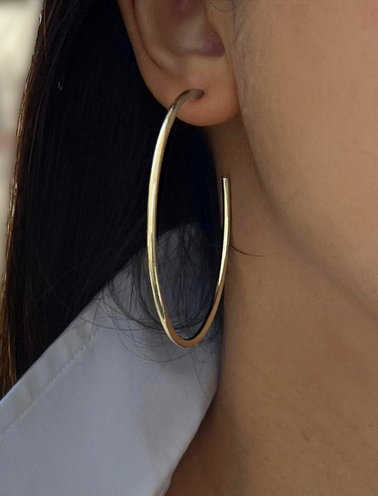 Female model wearing big medium large thin round circle PERFECT 50mm or 2 inch hoop stacking lightweight everyday statement earrings in 925 Sterling Silver by Sonia Hou, a celebrity AAPI Chinese demi-fine jewelry designer
