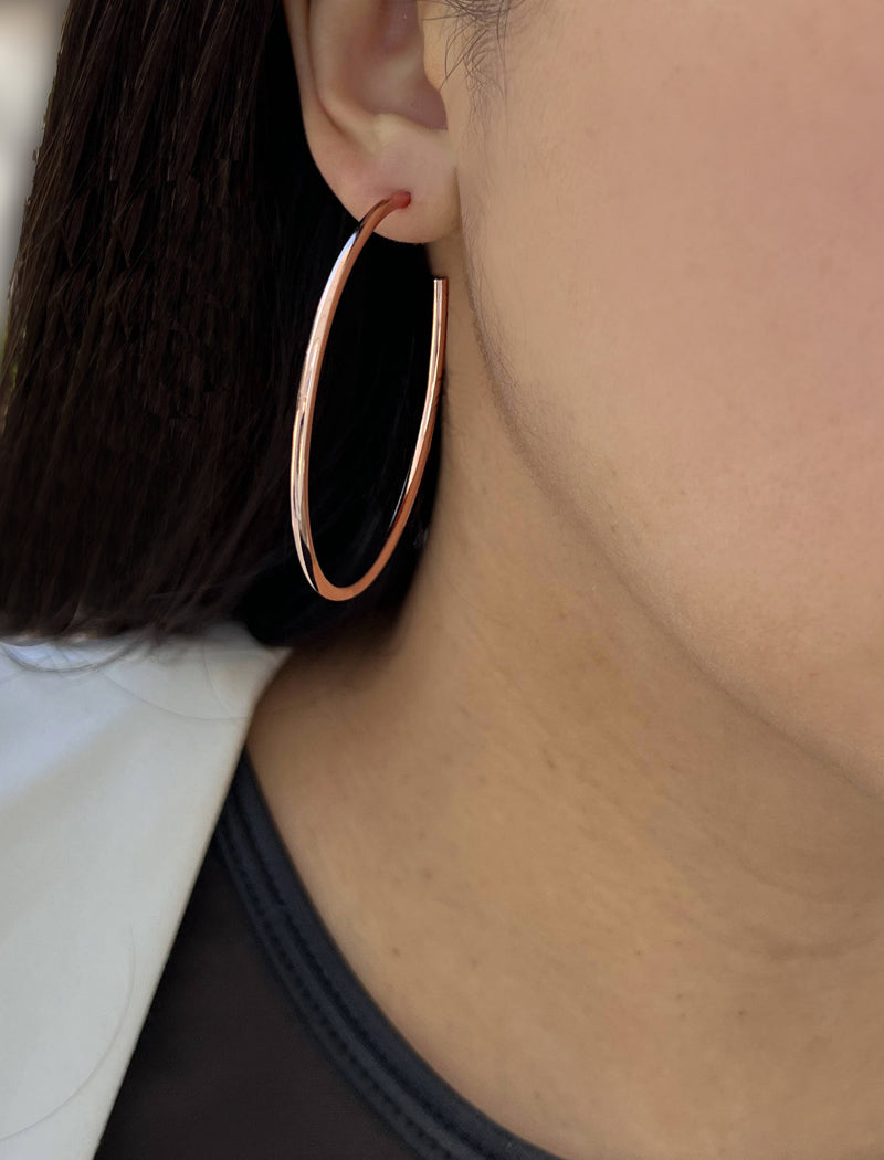 Female model wearing big medium large thin round circle PERFECT 50mm or 2 inch hoop stacking lightweight everyday statement earrings in 18K rose gold vermeil with a 925 Sterling Silver base by Sonia Hou, a celebrity AAPI Chinese demi-fine jewelry designer