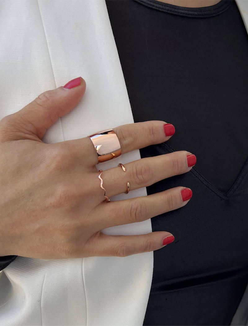 Female model wearing wide RICH thick bold chunky statement cigar band ring in 18k rose gold vermeil with 925 sterling silver base by Sonia Hou, a celebrity AAPI Chinese demi-fine jewelry designer