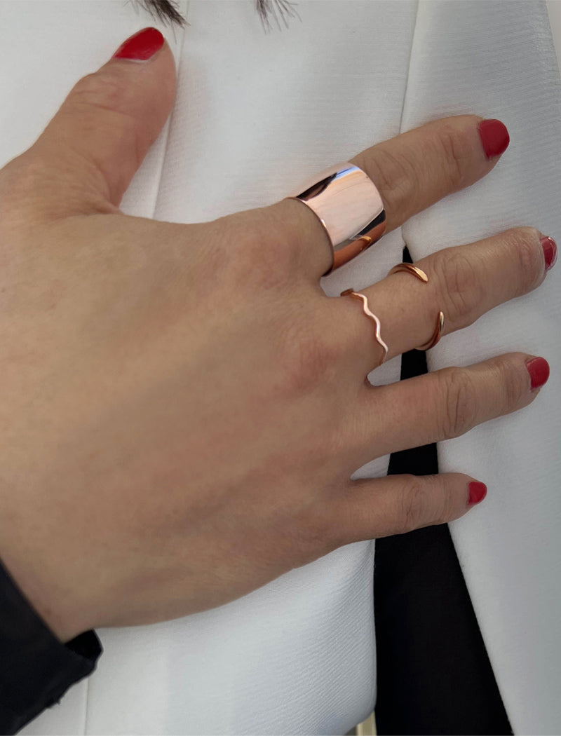 Female model wearing wide RICH thick bold chunky statement cigar band ring in 18K rose gold vermeil with a 925 sterling silver base by Sonia Hou, a celebrity AAPI Chinese demi-fine jewelry designer