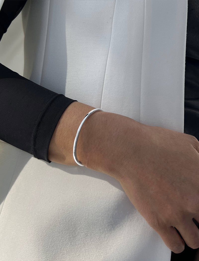 Female model wearing adjustable minimalist simple Success Thin Cuff Chunky Bold Layering Stacking Statement 2 Way convertible Bangle Cuff Open Bracelet in 925 sterling silver by Sonia Hou, a celebrity AAPI Chinese demi-fine fashion costume jewelry designer
