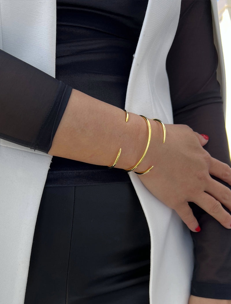 Female model wearing adjustable minimalist simple Success Thin Cuff Chunky Bold Layering Stacking Statement 2 Way convertible Bangle Cuff Open Bracelet in 18K Gold Vermeil with 925 sterling silver base by Sonia Hou, a celebrity AAPI Chinese demi-fine fashion costume jewelry designer