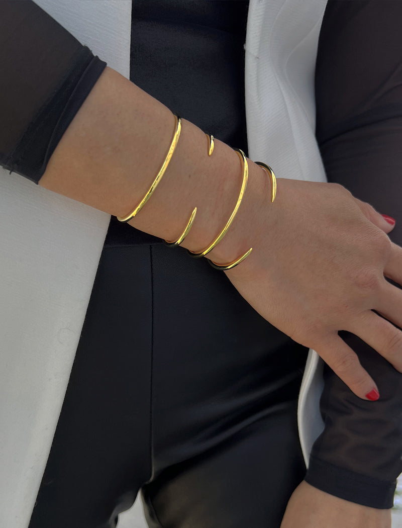 Female model wearing adjustable minimalist simple Success Thin Cuff Chunky Bold Layering Stacking Statement 2 Way convertible Bangle Cuff Open Bracelet in 18K Gold Vermeil with 925 sterling silver base by Sonia Hou, a celebrity AAPI Chinese demi-fine fashion costume jewelry designer